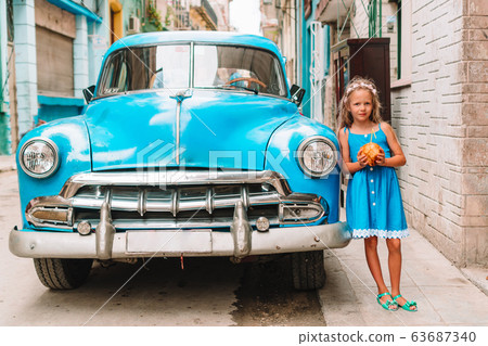 Tourist girl in popular area in Havana, Cuba. Young kid traveler smiling Tourist girl in popular area in Havana, Cuba. Young kid traveler smiling 63687340