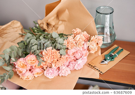 Flower set on wooden table. Fresh cut flowers for decoration home. Delivery flower. 63687609