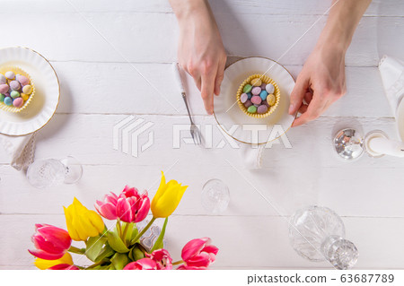 Top view male hands serving Easter table with Top view male hands serving Easter table with 63687789