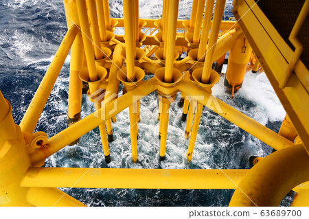 Well head slot from ground to main production floor and controlled by automation logic for production oil and gas industry. Offshore construction platform for production oil and gas in the gulf. Well head slot from ground to main production floor and controlled by automation logic for production oil and gas industry. Offshore construction platform for production oil and gas in the gulf. 63689700