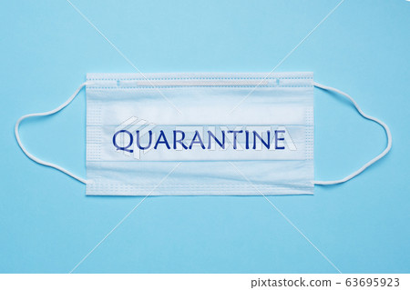 Disposable medical face masks. The concept of prevention of the virus. Blue background. Inscription Quarantines. Disposable medical face masks. The concept of prevention of the virus. Blue background. Inscription Quarantines. 63695923