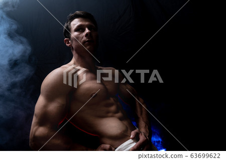 Muscular man showing muscles isolated on the black background. Concept of goal, afford, creation your self, perseverance, fortitude, focus and labor 63699622