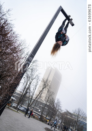 Young attractive Girl hanging by feet upside down on the street light in the street. super extreem. concept of courage and meditation Young attractive Girl hanging by feet upside down on the street light in the street. super extreem. concept of courage and meditation 63699678