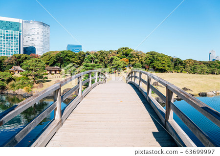Hamarikyu Gardens wooden bridge and pond in Tokyo, Japan 63699997