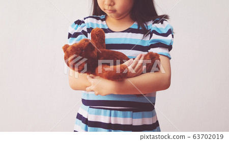 asia girl hugging a teddy bear 63702019