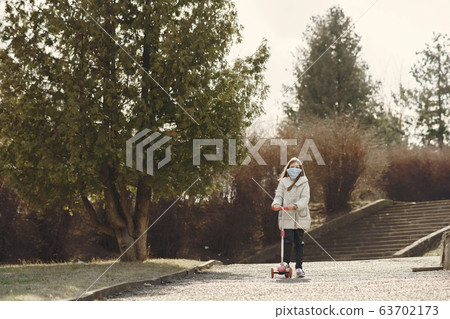 Little child walks outside in a mask 63702173