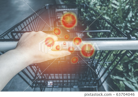 Asian hand holding shopping cart handle contaminated with germs 63704046