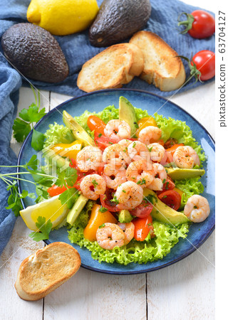 Delicious avocado tomato salad with fried prawns and toasted baguette Delicious avocado tomato salad with fried prawns and toasted baguette 63704127