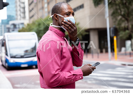 African American wearing covid19 coronavirus mask in the street 63704368