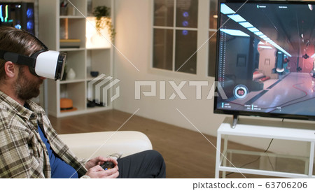Bearded man with long hair taking off vr headset Bearded man with long hair taking off vr headset 63706206