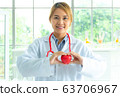 Woman doctor holding a red heart, health medical 63706967