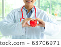 Woman doctor holding a red heart, health medical 63706971
