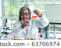 Senior male supervisor doing experiments and 63706974