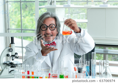 Senior male supervisor doing experiments and 63706974