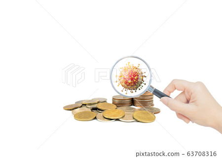 Hand holding magnifying glass and inspecting stacked coins. 63708316