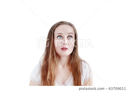Headshot of young natural surprised or shocked woman with long hair and natural make-up 63709011