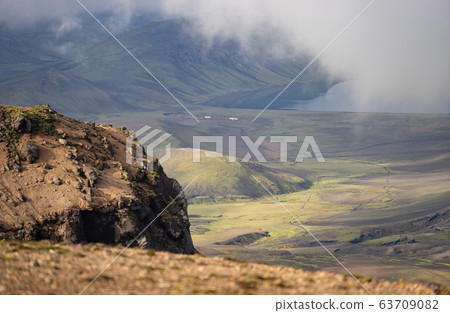 View on Hvanngil mountain hut and camp site with green hills, river stream and lake. Laugavegur hiking trail, Iceland 63709082