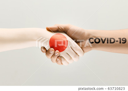 Human hands colored in flag of Japan and coronavirus - concept of spreading of virus 63710823