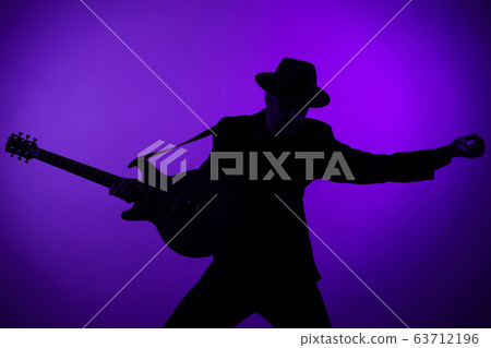 silhouette of a guitarist in a hat on a blue silhouette of a guitarist in a hat on a blue 63712196