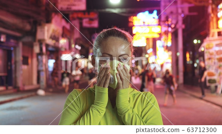 Woman close up look caucasian at Pattaya Walking Street with wearing protective medical mask. Lockdown quarantine isolation. Coronavirus covid-19. 63712300