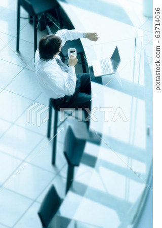 在櫃檯工作時看著手錶的商人 在櫃檯工作時看著手錶的商人 63714056