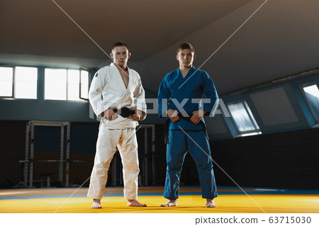 Two young judo fighters in kimono posing comfident in the gym, strong and healthy 63715030