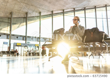 Woman stucked at airport terminal over flight cancellation,calling family, sitting in almost empty airport terminal due to coronavirus pandemic, Covid 19, outbreak travel restrictions Woman stucked at airport terminal over flight cancellation,calling family, sitting in almost empty airport terminal due to coronavirus pandemic, Covid 19, outbreak travel restrictions 63715490