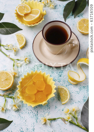 Lemon jelly candies with fresh lemons on light background,top view 63716509