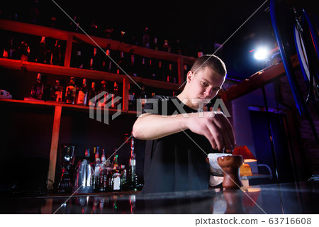 Barman fills black burnt ceramic bowl for hookah smoking different types of tobacco. 63716608