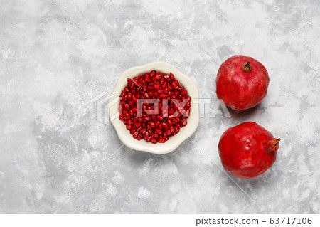 Pomegranate seeds with pomegranate on concrete background Pomegranate seeds with pomegranate on concrete background 63717106