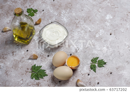 Mayonnaise sauce and ingredients on brown concrete background. Top view 63717202