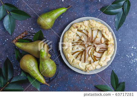 Homemade pear galette pie with almond leaves and fresh ripe green pears 63717281