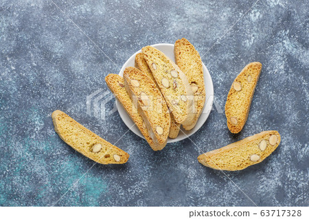 Italian tuscan traditional cookies cantuccini with almonds on grey concrete background,top view Italian tuscan traditional cookies cantuccini with almonds on grey concrete background,top view 63717328