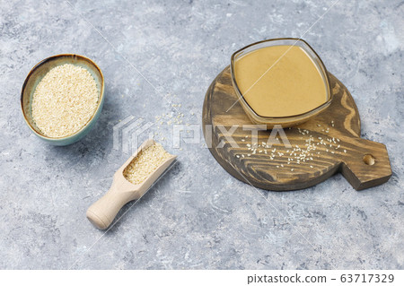 Bowl of tahini with sesame seeds on concrete background Bowl of tahini with sesame seeds on concrete background 63717329