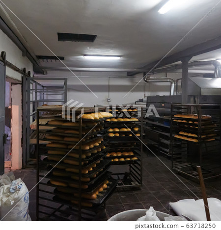 Baking tray with tasty bread, indoors. Pallets with freshly baked bread. Industrial production of bread in the bakery Baking tray with tasty bread, indoors. Pallets with freshly baked bread. Industrial production of bread in the bakery 63718250