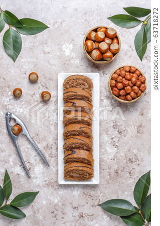 Delicious sweet chocolate cake roll with hazelnut cream and hazelnuts,top view 63718272
