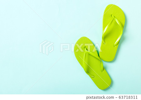 green flip flops on blue background. Top view with 63718311