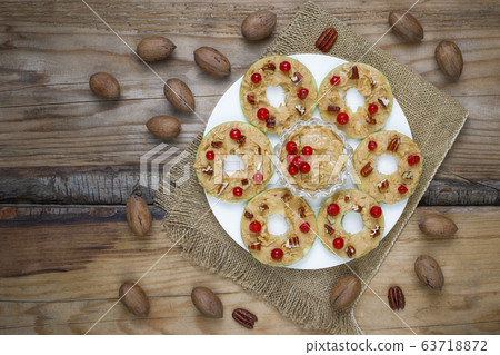 Healthy sandwich. Green apple rounds with peanut butter and red currant and pecan nuts on rustic background,top view Healthy sandwich. Green apple rounds with peanut butter and red currant and pecan nuts on rustic background,top view 63718872
