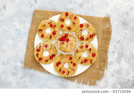 Healthy sandwich. Green apple rounds with peanut butter and red currant and pecan nuts on grey concrete background,top view Healthy sandwich. Green apple rounds with peanut butter and red currant and pecan nuts on grey concrete background,top view 63719266