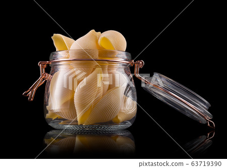 Jar of conchiglie pasta shell on wooden table Jar of conchiglie pasta shell on wooden table 63719390