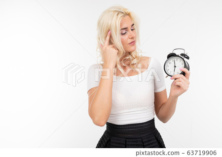 girl in white hair sets the alarm clock for morning in the hand on an isolated white background girl in white hair sets the alarm clock for morning in the hand on an isolated white background 63719906