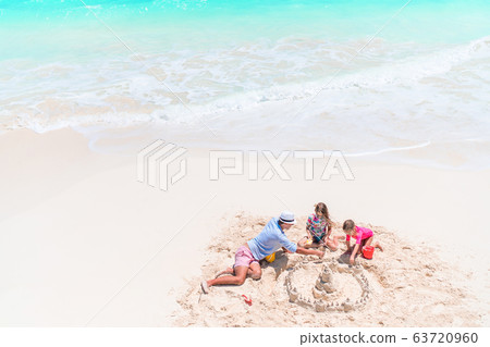 Happy beautiful family on a tropical beach vacation Happy beautiful family on a tropical beach vacation 63720960