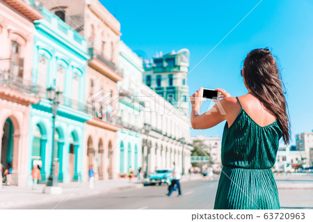 Tourist girl in popular area in Havana, Cuba. Young woman traveler smiling happy. Tourist girl in popular area in Havana, Cuba. Young woman traveler smiling happy. 63720963