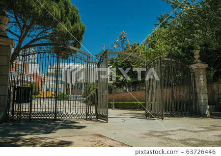Gateway and wrought iron fence on garden in Madrid 63726446