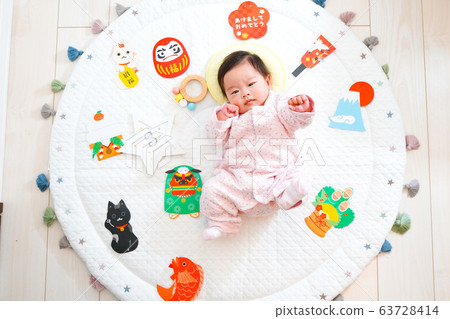 A baby doing a goo punch surrounded by New Year's decorations A baby doing a goo punch surrounded by New Year's decorations 63728414