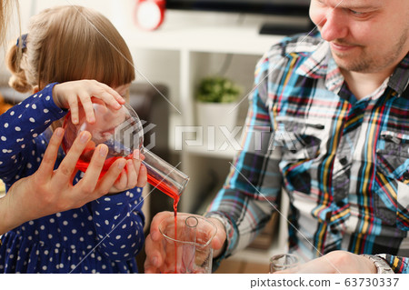 Man and little girl play with colourful liquids 63730337