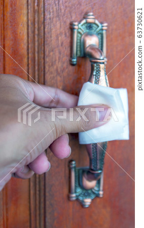 Using hand open the door with paper wipe on knob prevent covid19 virus. 63730621
