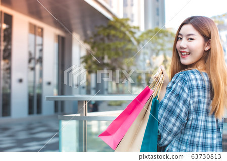 Smiling young Asian woman with shopping colour Smiling young Asian woman with shopping colour 63730813