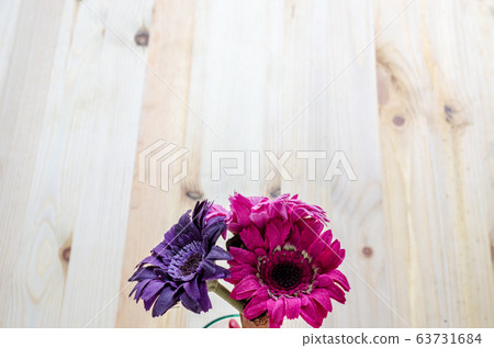 Beautiful artificial flowers on wooden background Beautiful artificial flowers on wooden background 63731684