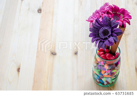 Beautiful artificial flowers on wooden background Beautiful artificial flowers on wooden background 63731685